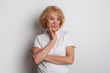 Mature woman portrait. Mid adult woman standing against white studio wall background