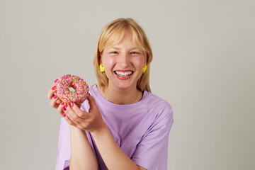 Young smiling woman holding a donut