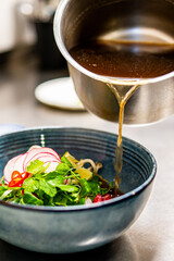 Close up of chef's hands cooking asian pho bo soup on restaurant kitchen