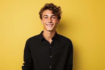Obraz premium Teenage boy, Male employee wearing a black shirt yellow background
