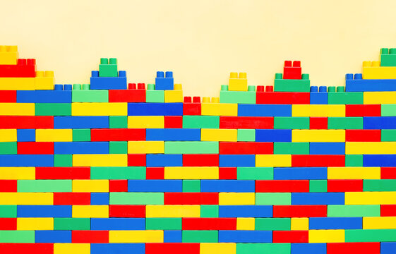 Creative Wall on yellow background: Constructible Toy Bricks for Imaginative Kids. Educational toys for kids. Colorful plastic brick blocks. Education, children's creativity