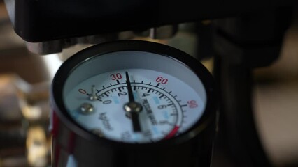 The pressure gauge needle moves around the dial and measures the variable pressure in the system. Air pressure gauge in the air pump, close up