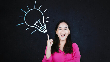Asian woman having great idea against blackboard with lightbulb doodle