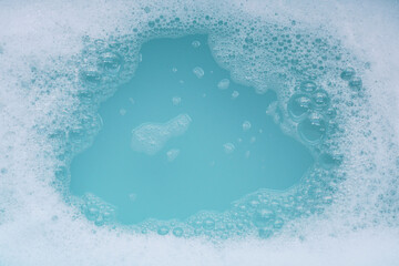 Detergent foam bubble on water. Blue background, Soap sud