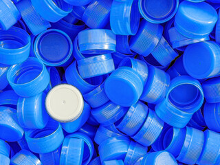 Grey plastic bottle caps on top to depict the concept of standing out from the crowd, dare to be different, odd man out, success or a leadership concept.