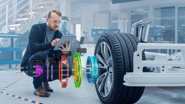 Automotive Engineer Working on Electric Car Chassis, Using Augmented Reality Headset with 3D VFX Application for Development of Regenerative Braking System on a Futuristic Transport Vehicle.