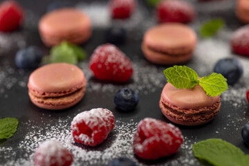 macaroons of different colors on a black background