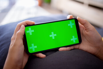 a green phone screen in the hands of a teenage girl. Copy space for advertising and text.
