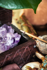 amethyst geode in a wooden box with quartz and selenite with incense stick