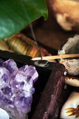 amethyst geode in a wooden box with quartz and selenite with incense stick