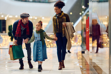 Happy multiracial family in Christmas shopping at mall.