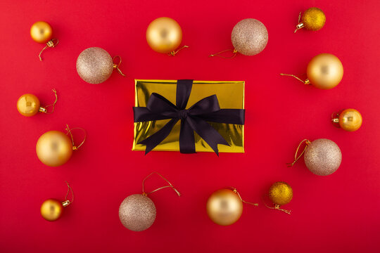 New Year concept. Top view photo of trendy gift boxes with bows red green baubles and gold star ornaments on isolated red background with copyspace in the middle.