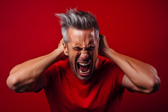 Upset boy, man in red t shirt screaming and crying with opened mouth and closed eyes against