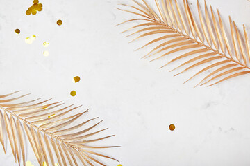  Minimalist background with golden artificial palm leaves with copy space. Place for New Years...