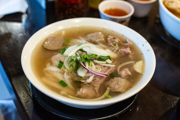 Classic Vietnamese Combination Beef Pho Topped with Freshly Onion and Coriander, Served in a Restaurant