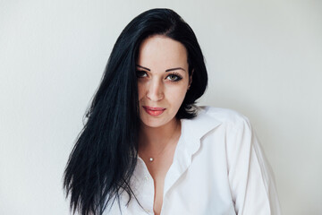 Fototapeta premium Portrait of a beautiful brunette woman in a white business suit