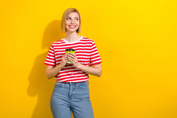 Photo of girlish woman with bob hairstyle dressed striped t-shirt hold cup of coffee look empty space isolated on vibrant yellow background