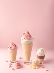 
ice creams in glass glasses of different sizes with decoration with a pink background