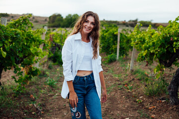 Beautiful brown-haired woman in a vineyard at sunset