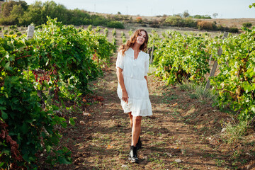 Beautiful woman in white dress in vineyard
