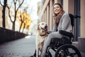 beautiful woman in wheelchair sitting on sidewalk with his golden retriever dog