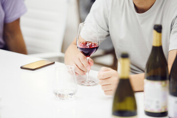 Wine experts association, sommelier school, professional development. Sommelier tasting red wine from glass, analysing its taste, color, smell and acidity level. 