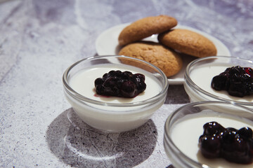 Vanilla panna cota with berries jam in transparent bowls