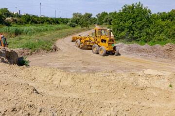 Grader is leveling ground at construction site