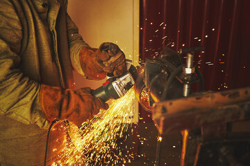 Worker cuts steel with a grinder, close-up
