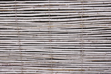 Texture of thin wooden curtain poles. Beach background.
