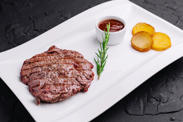 big juicy steak with potatoes on plate