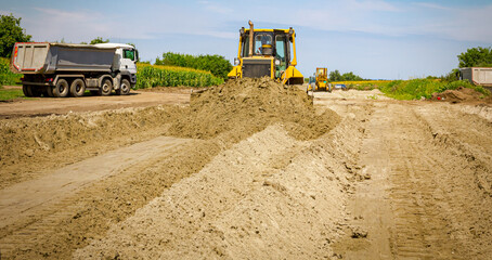 Bulldozer machine is leveling construction site.