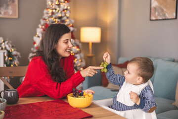 Toddler having fruit snack on Christmas day at home