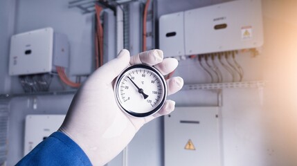 Measuring the temperature of the inverter power control room using an analog thermometer, a normal...
