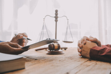 Justice and Law concept. Legal counsel presents to the client a signed contract with gavel and...