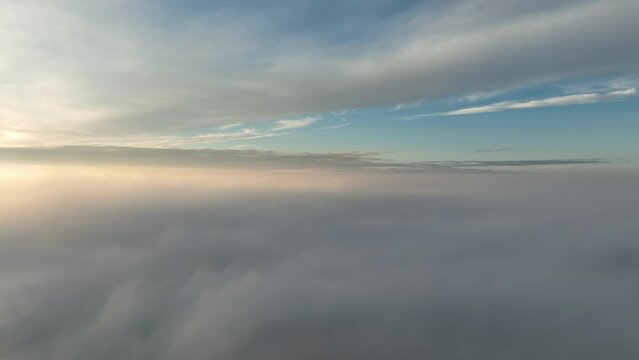 Beautiful sky above the low clouds with sunlight over the fluffy clouds. Flying Drone view.