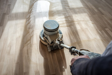 Polishing wooden parquet floor with special orbital machine - obrazy, fototapety, plakaty