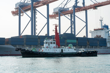 Big crane loading cargo container from truck to container ship in the international terminal...