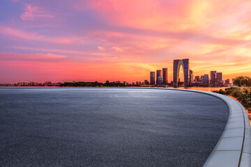 Asphalt road square and city skyline with modern buildings at sunset in Suzhou, Jiangsu Province,...