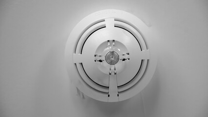 Fire alarm on a ceiling black and white