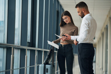 Checking the valid information. Woman is with airport worker, with tickets