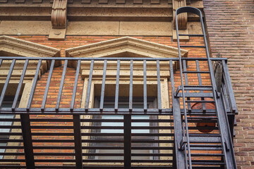 Close-up at part of classic designed fire escape ladder that installed on the American style building or apartment. Building safety equipment for transportation, Selective focus.