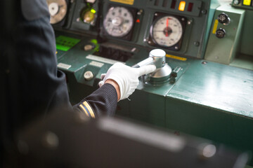 Action of train driver is controlling the accelerator lever to speed up the train. Transportation working scene photo, selective focus at human hand.