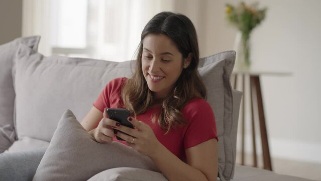 Charming caucasian woman with smartphone read messages from boyfriend smiling at home. 
