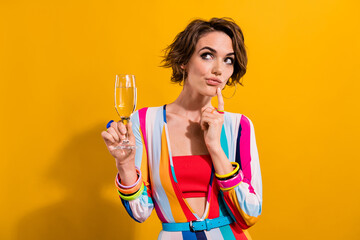 Photo of doubtful unsure uncertain lady wear striped costume drinking champagne looking empty space isolated yellow color background - obrazy, fototapety, plakaty