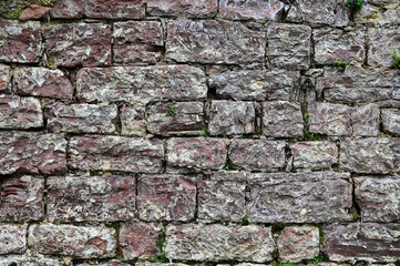 Stone wall with natural stones and moss as a background with copy space