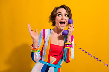 Photo of impressed funky lady wear striped costume talking phone looking empty space isolated yellow color background - obrazy, fototapety, plakaty