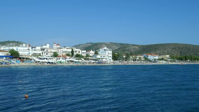 Small tourist village of Potos in the southern end of Thassos Island in Greece , Europe with the specific architecture and blue Aegean Sea , seen from the pier , sunny summer day.