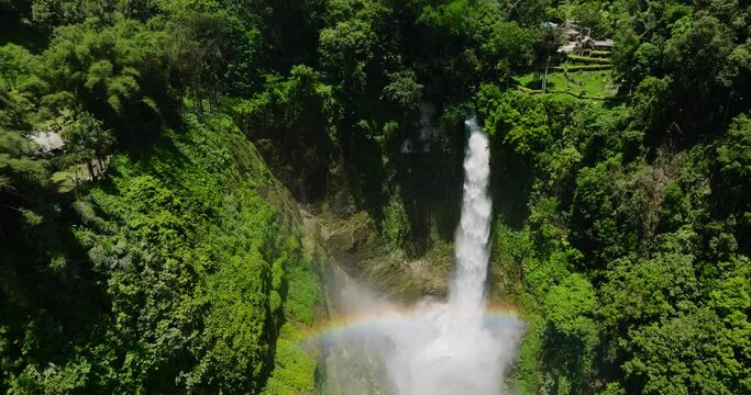 Beautiful waterfall in the jungle of Lake Sebu. A stream of waterfalls from high rocks, splitting into streams, creating mist. Rainbow. Mindanao, Philippines.