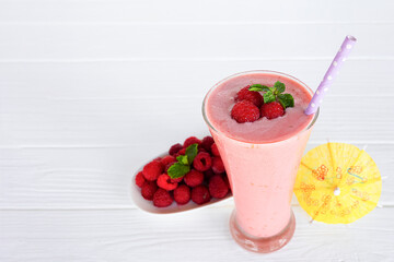 Raspberry smoothie red colorful fruit juice milkshake blend beverage healthy high protein the taste yummy In glass drink episode morning on white wood background.